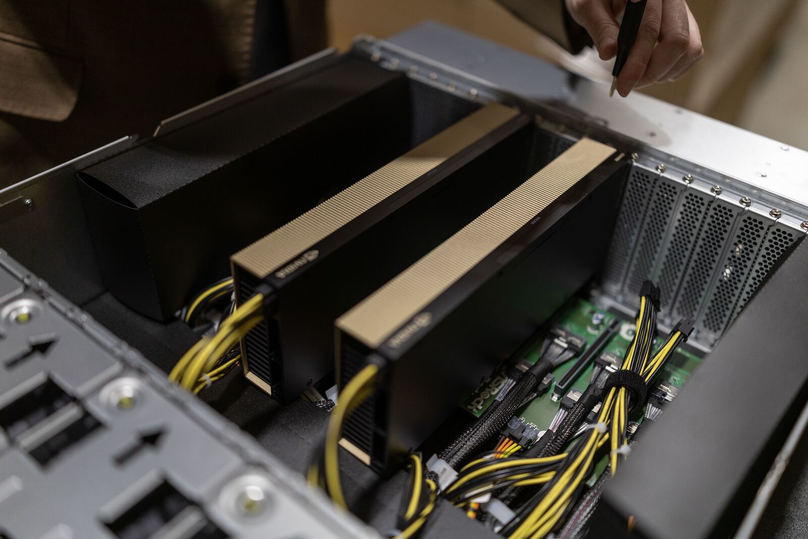 An opened rack-mount GPU node at 80 N Danebo showing installed accelerator cards, power cabling and the fan wall.